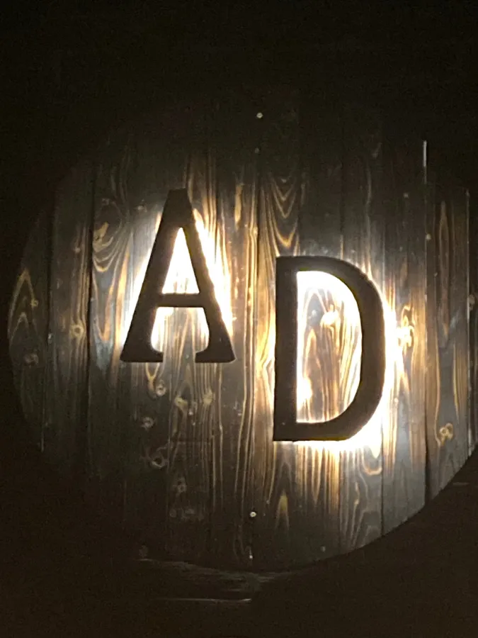 The backlit AD sign carved into the speakeasy wall