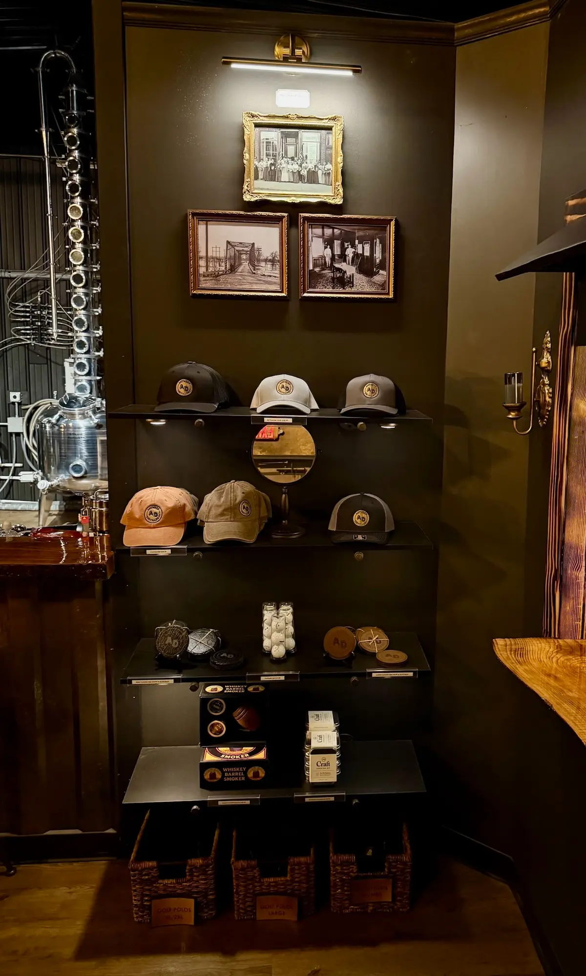 The merch shelves: embroidered AD caps, coasters, and barrel smoker kits beneath framed historic photos